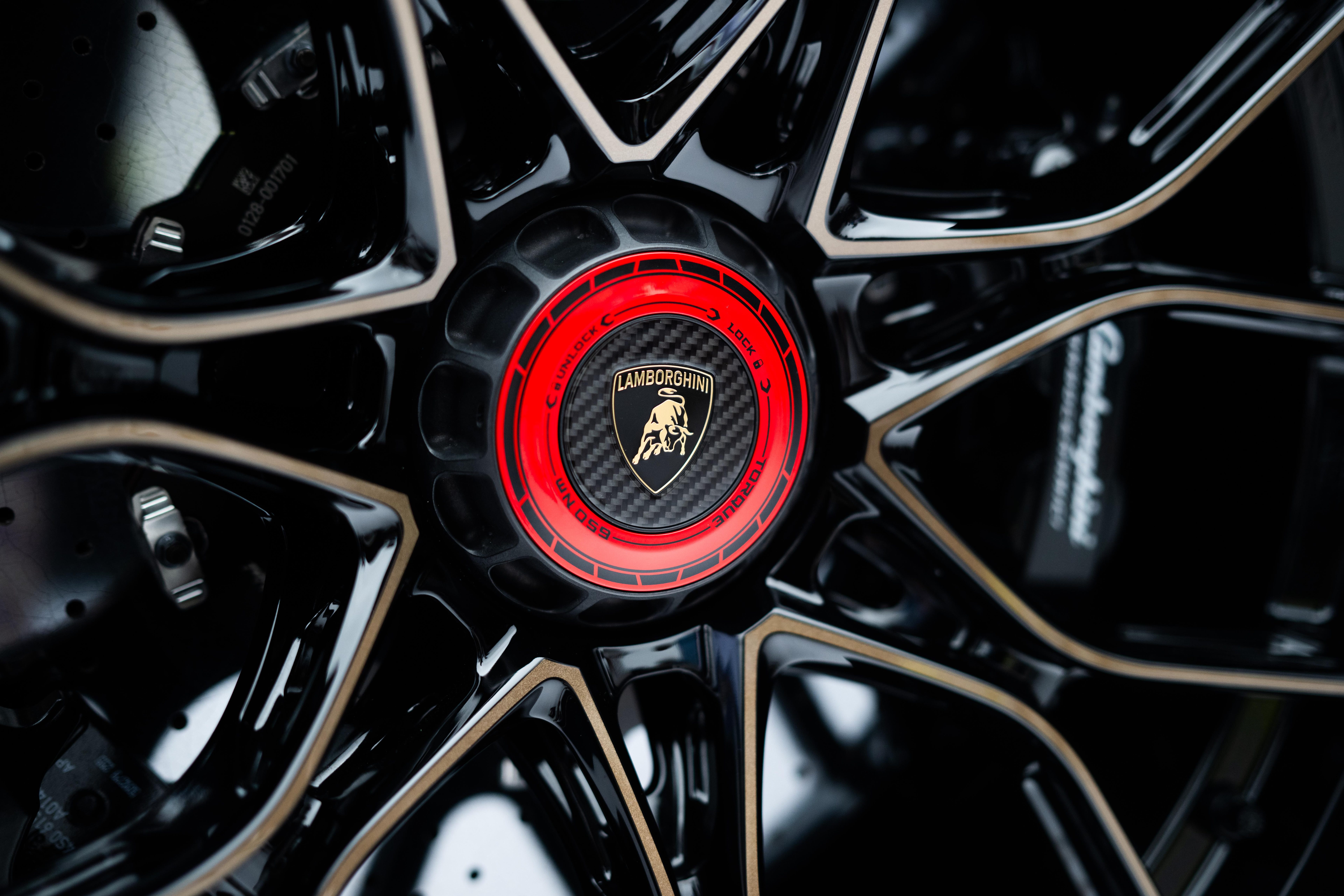 Close-up of the Revuelto SV's black multi-spoke wheel with red and black Lamborghini center cap and visible brake caliper