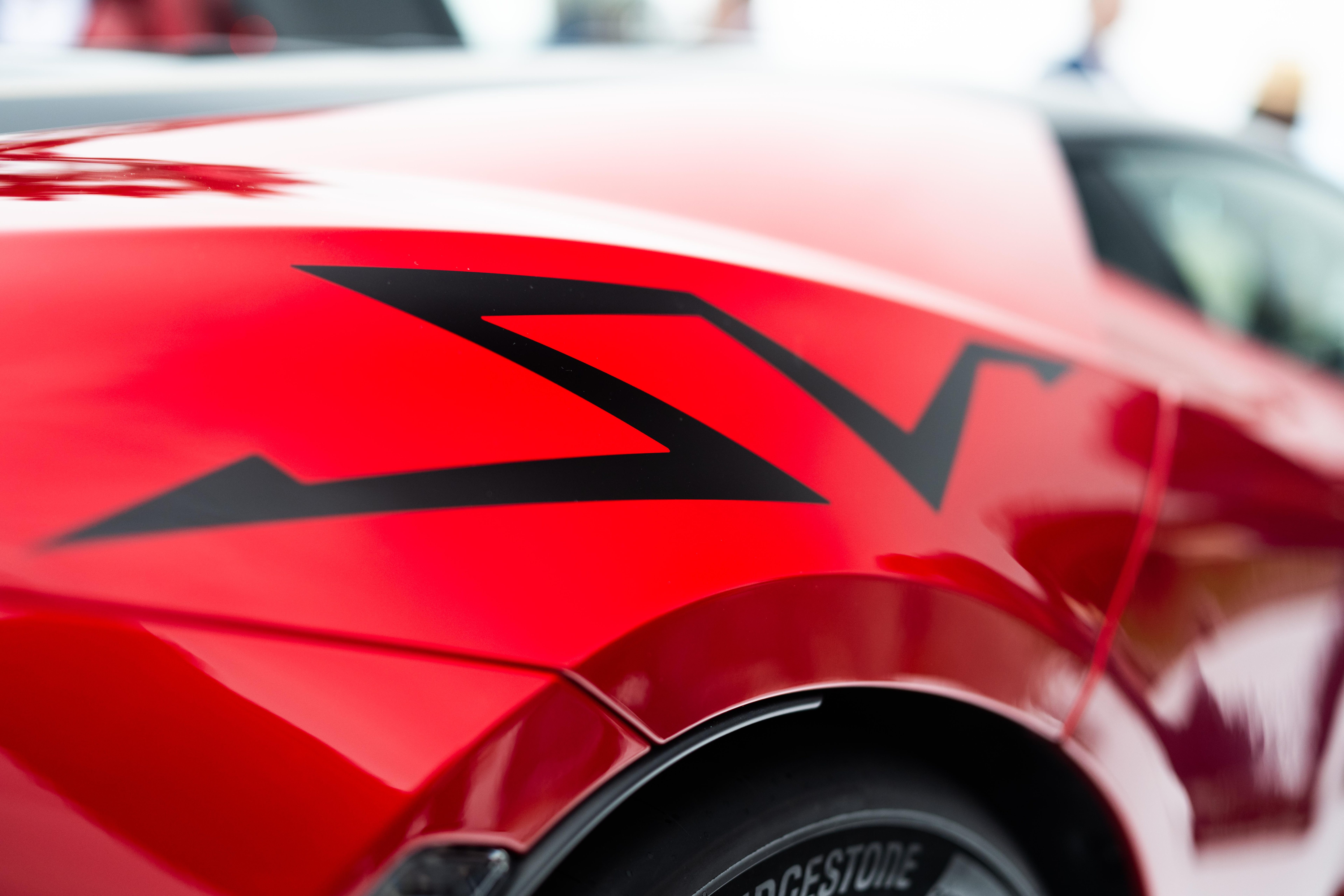 Close-up of the rear quarter panel showing the bold black SV graphic on red bodywork with Bridgestone tire visible