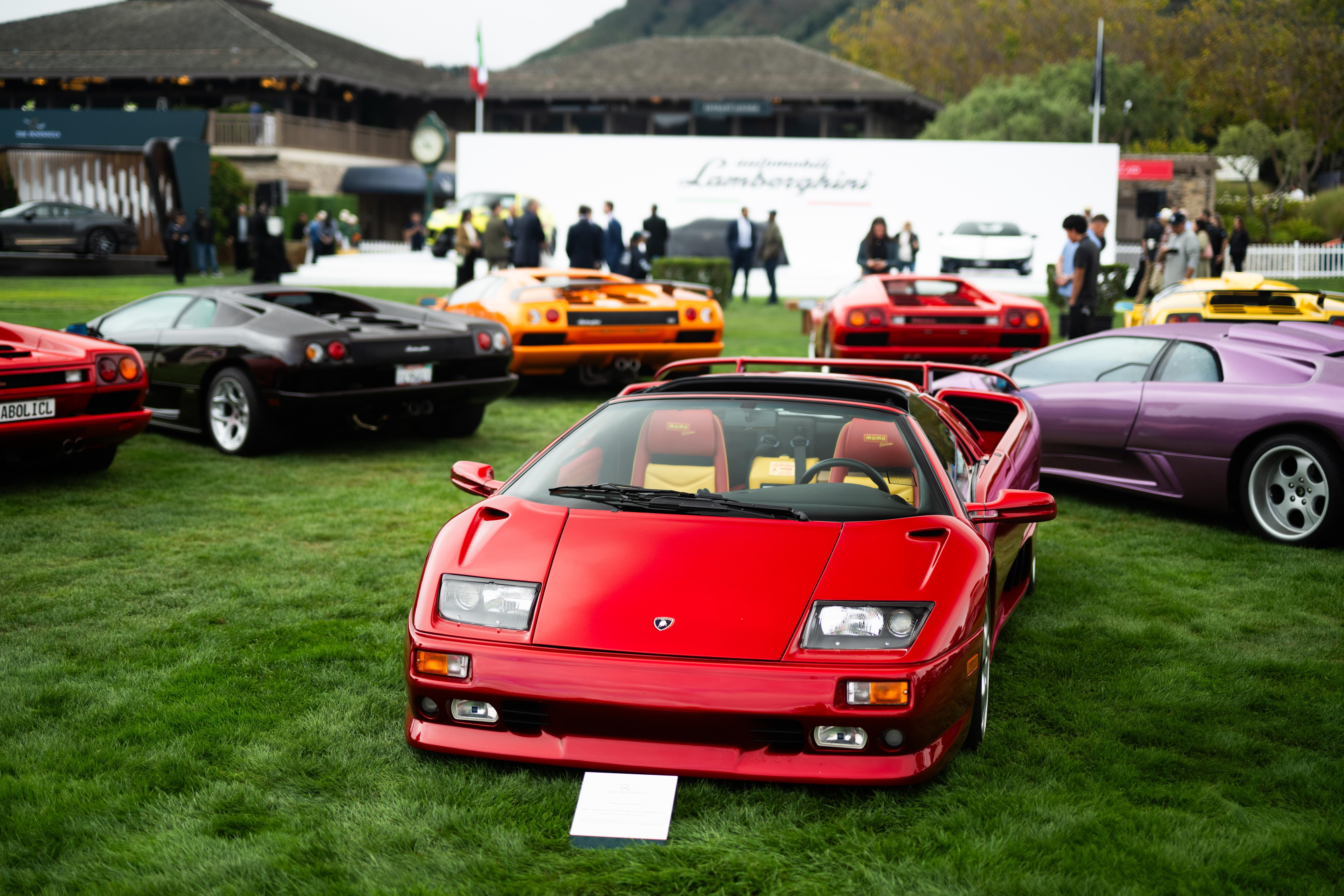 Red Lamborghini Diablo with yellow interior on the lawn at The Quail surrounded by other classic Lamborghinis