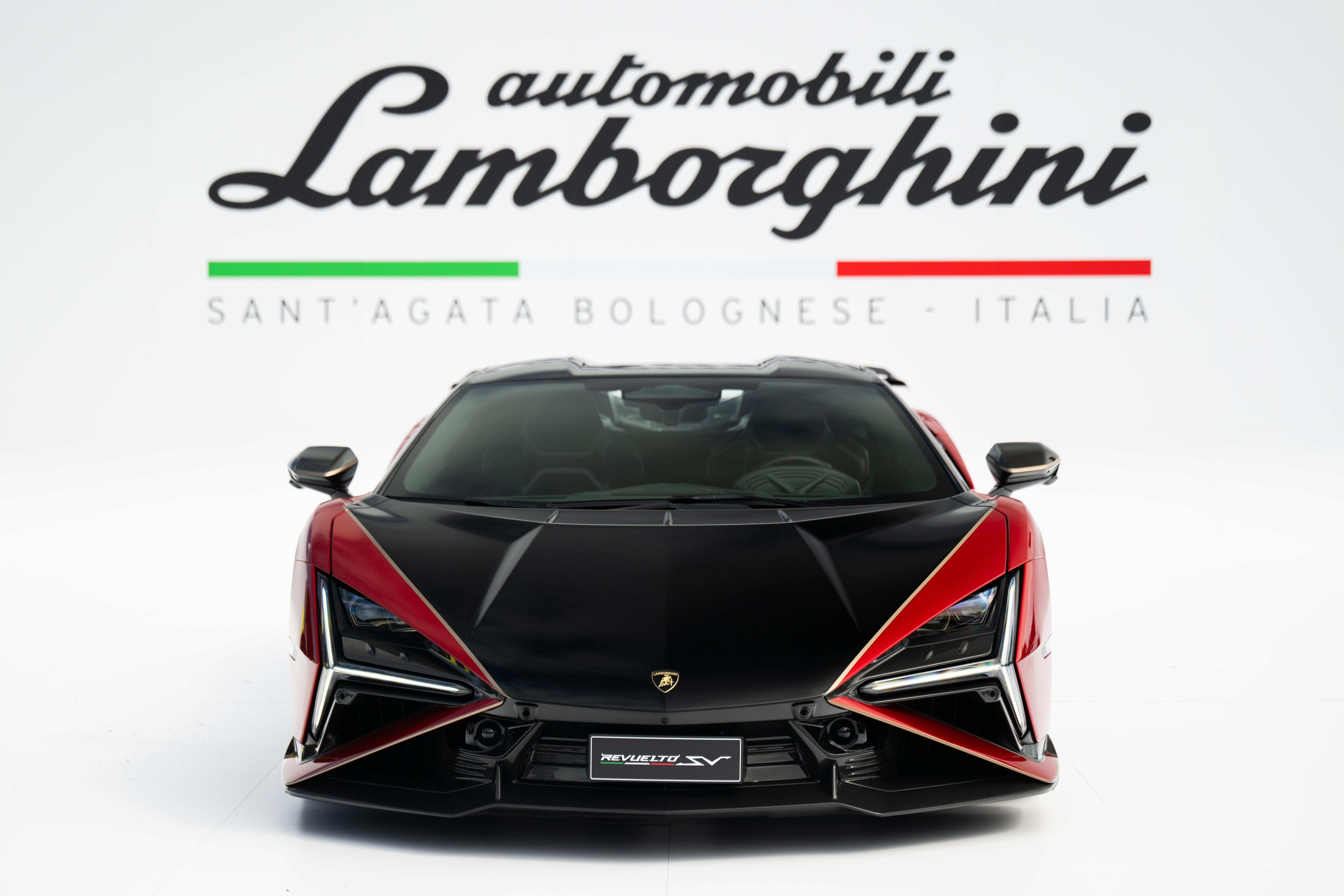 Head-on studio view of the black and red Lamborghini Revuelto SV against a white backdrop with Automobili Lamborghini branding
