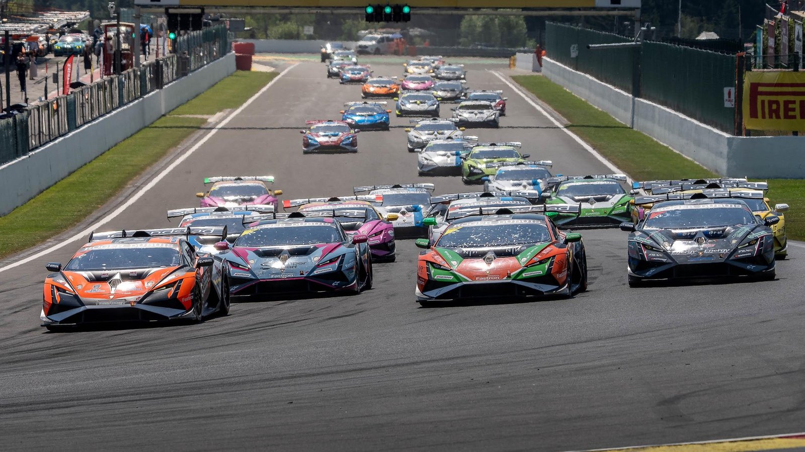 A pack of Lamborghini Huracán Super Trofeo EVO2 race cars in diverse liveries racing closely on track during the Super Trofeo Europe championship