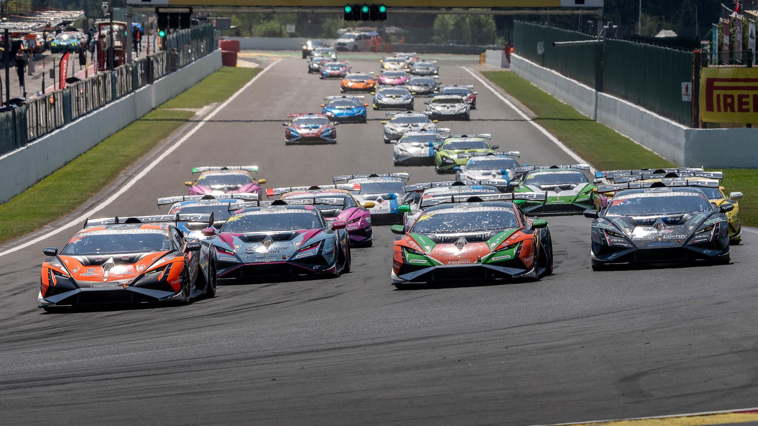 A pack of Lamborghini Huracán Super Trofeo EVO2 race cars in diverse liveries racing closely on track during the Super Trofeo Europe championship