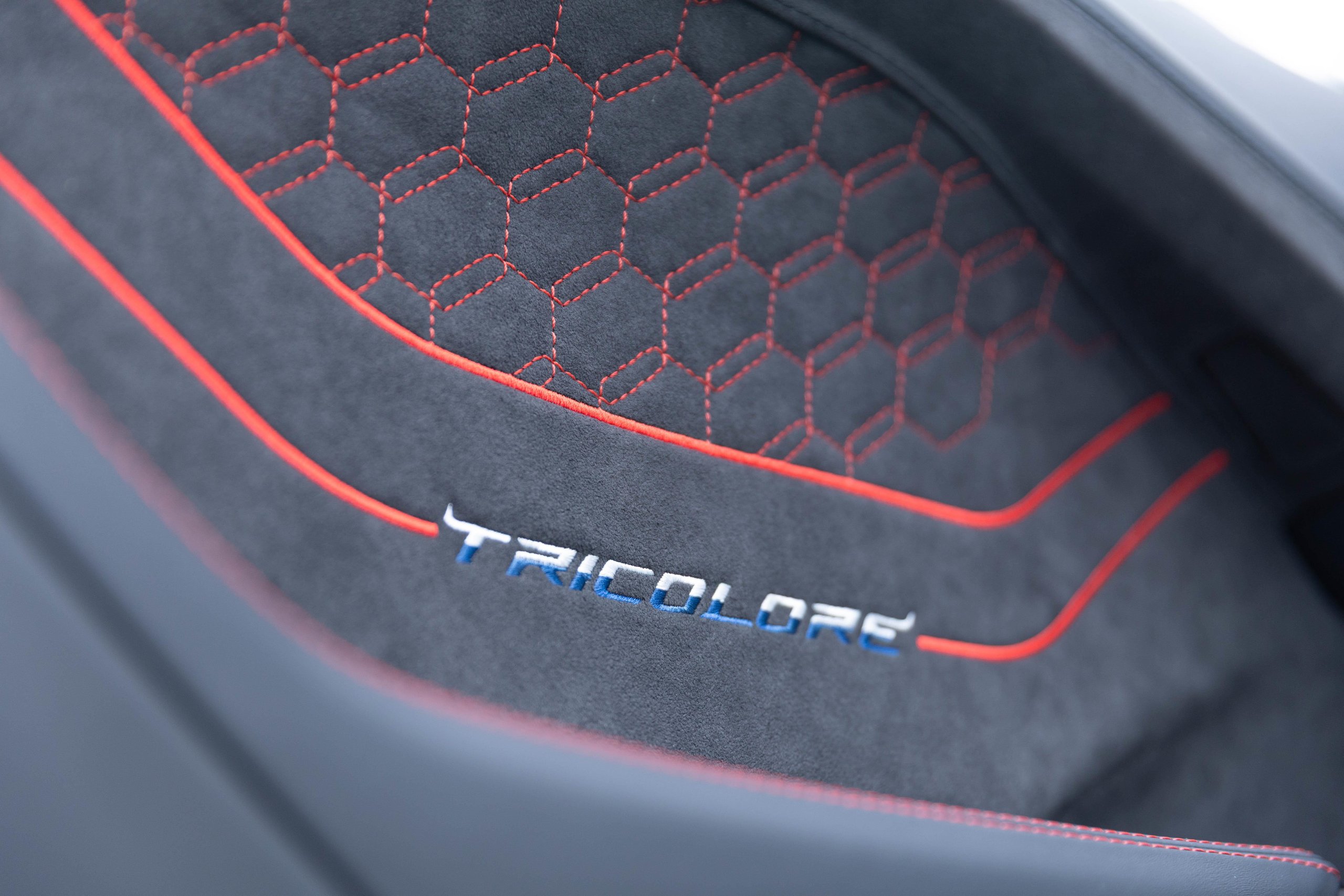 Close-up of Tricolore embroidery on Lamborghini Temerario interior panel with blue and red stitching and hexagonal pattern