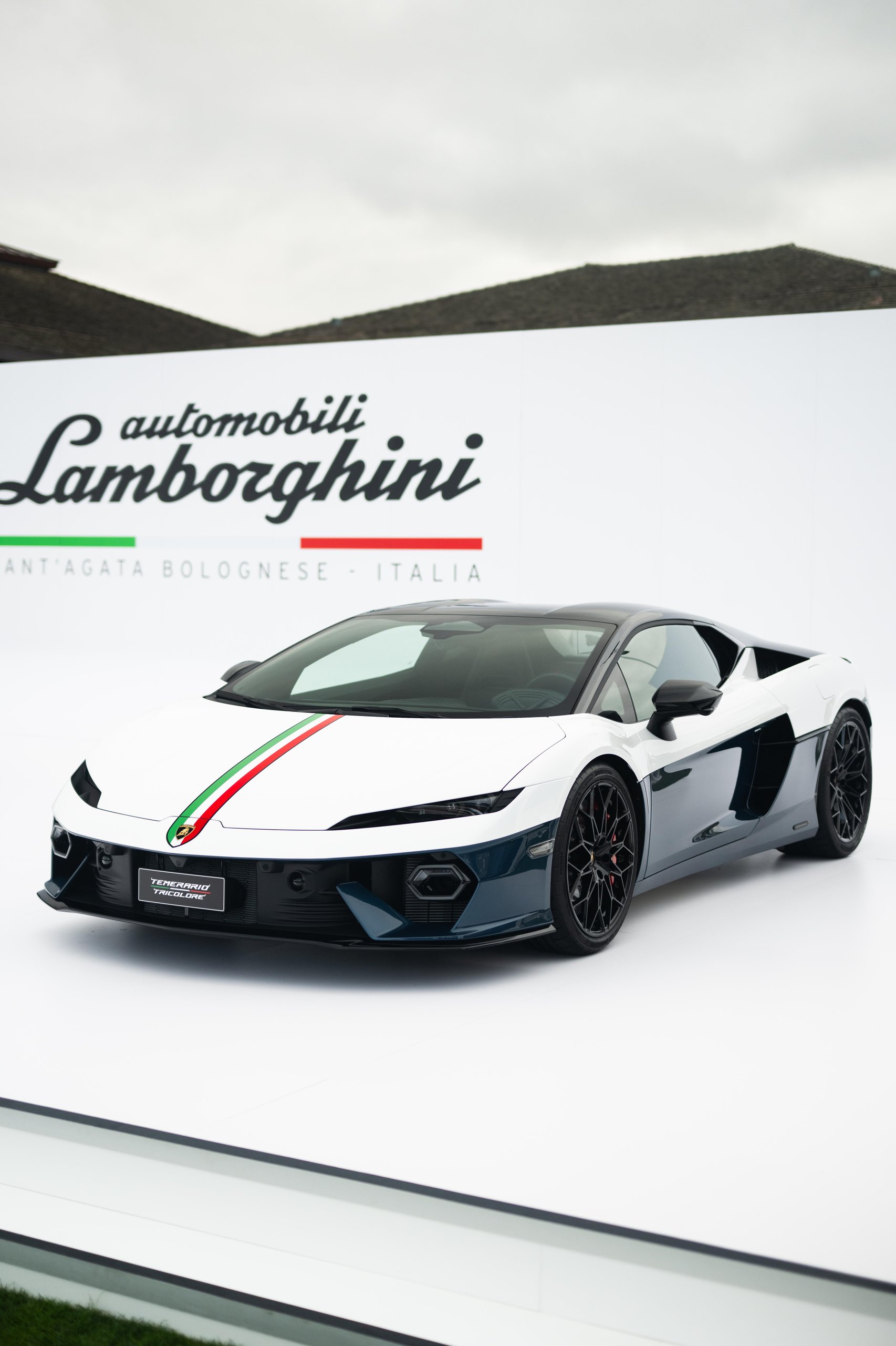 White Lamborghini Temerario Tricolore with Italian flag stripe displayed at outdoor event with Lamborghini backdrop