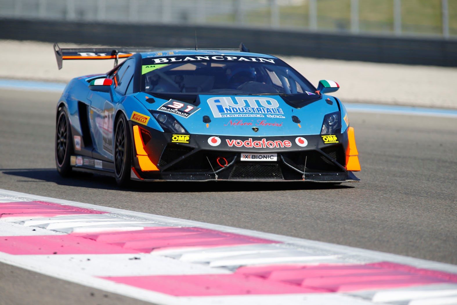 Blue Lamborghini Gallardo Super Trofeo race car with aerodynamic body kit, large rear wing, front splitter, and canards racing at Paul Ricard