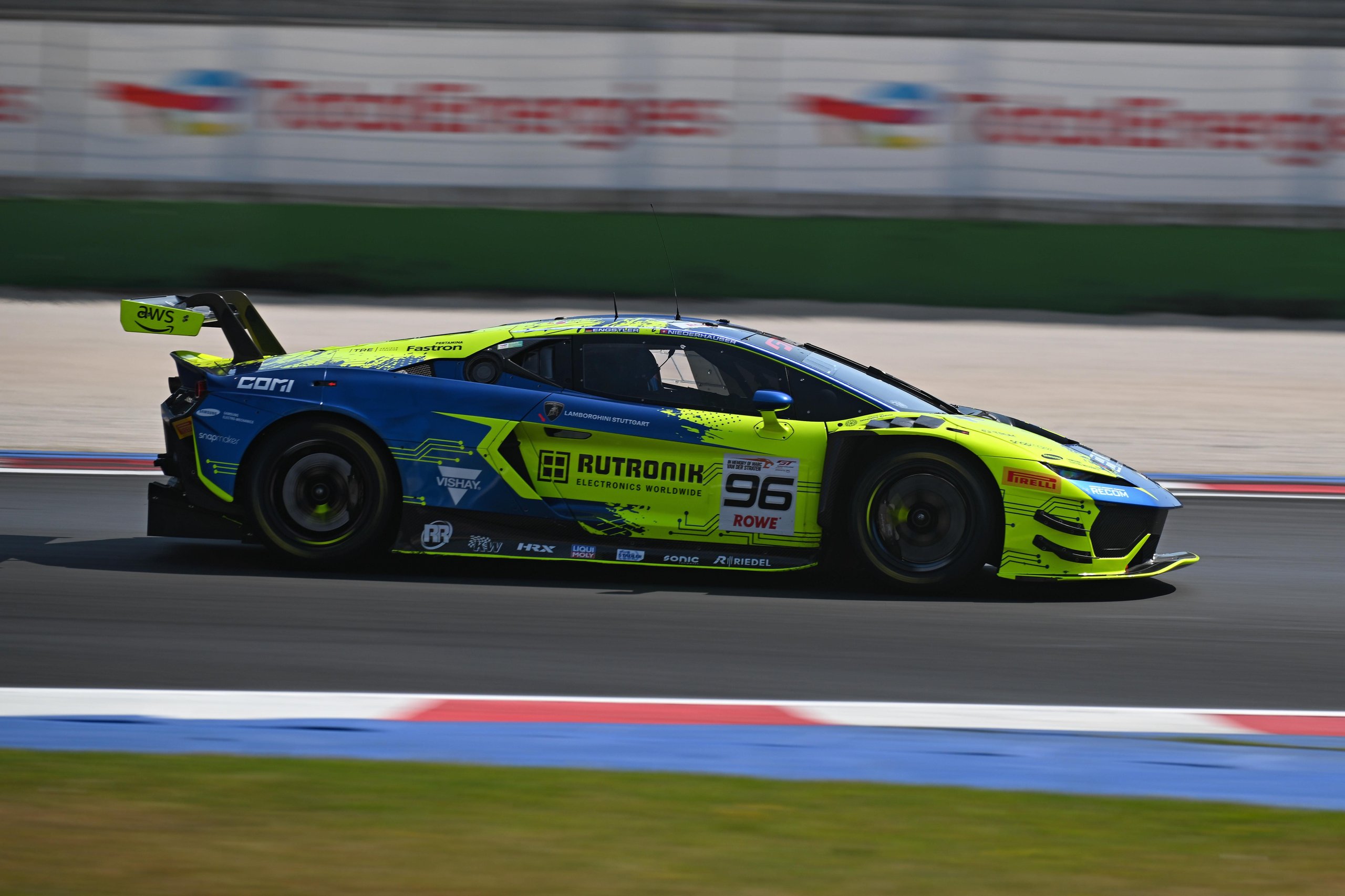 Temerario Gt3 Wins First Imsa Endurance Race At Road America, Five Months After Its Debut 9 A blue and yellow lamborghini temerario gt3 race car cornering hard on track, showing the aerodynamic body kit and large rear wing