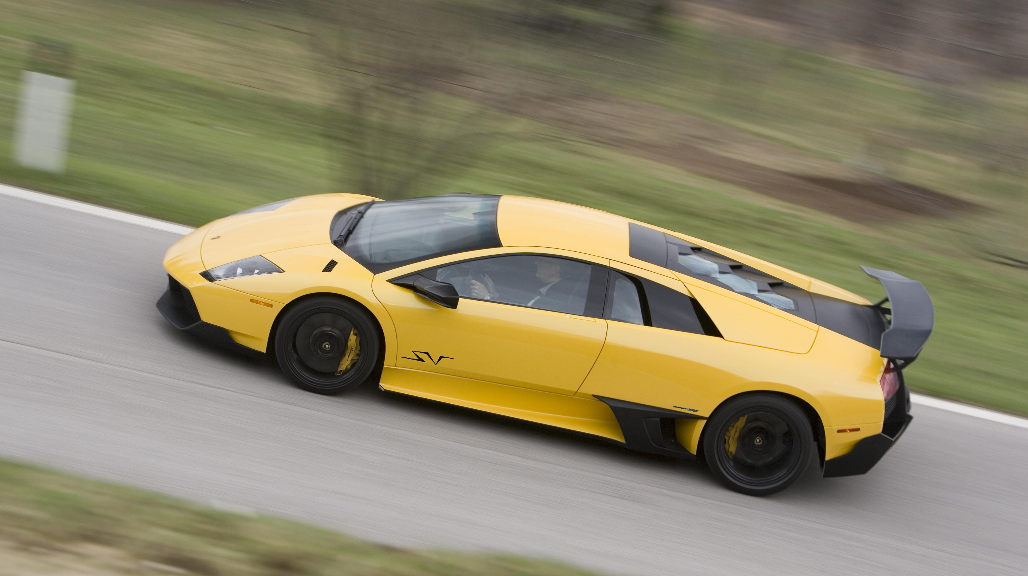 Yellow Lamborghini Murciélago LP 670-4 SV from above on a winding road, showing its large rear wing and SV badging